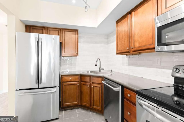 kitchen featuring brown cabinetry, appliances with stainless steel finishes, and a sink