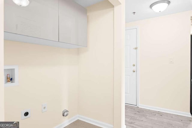 washroom with light wood-style flooring, electric dryer hookup, cabinet space, washer hookup, and baseboards
