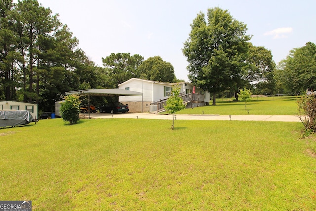 106 Paul Revere Dr, Cusseta, GA 31805 - view of grassy yard with a detached carport, driveway, and view of wooded area