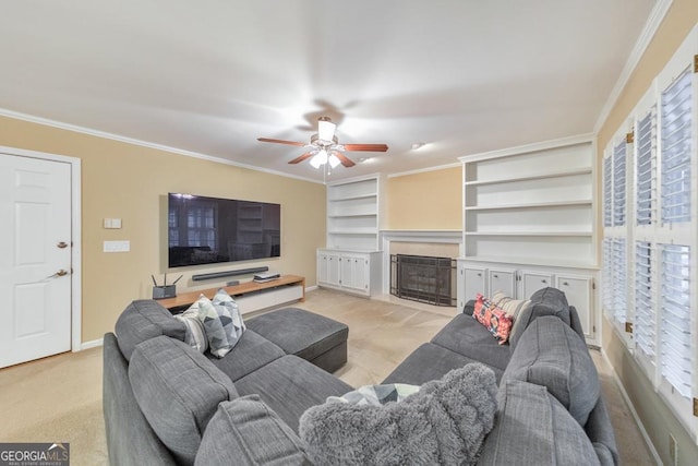 living area featuring baseboards, light colored carpet, ceiling fan, ornamental molding, and a fireplace