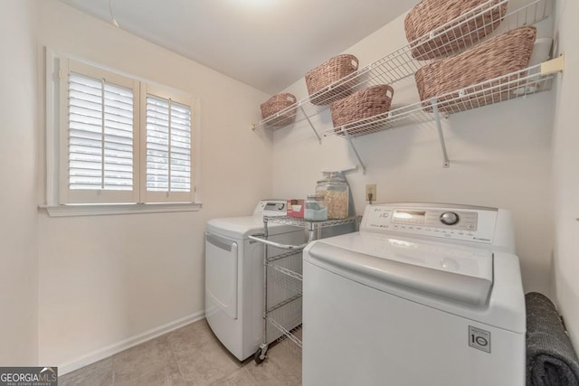 washroom featuring independent washer and dryer, baseboards, and light tile patterned floors