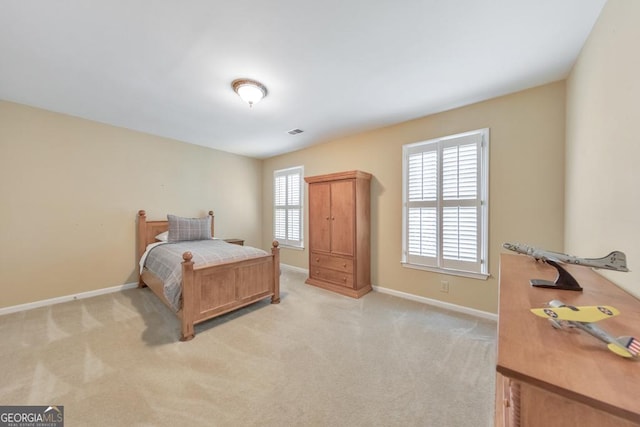bedroom featuring baseboards and light carpet
