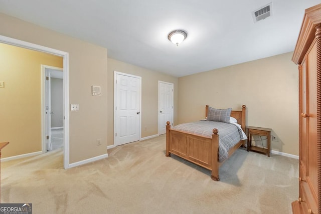 bedroom featuring light colored carpet and baseboards