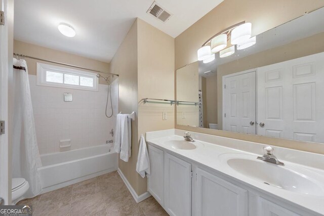 bathroom with toilet, double vanity, shower / bathtub combination with curtain, baseboards, and tile patterned floors