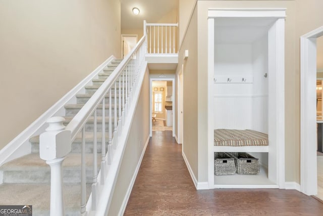 stairs featuring wood finished floors and baseboards