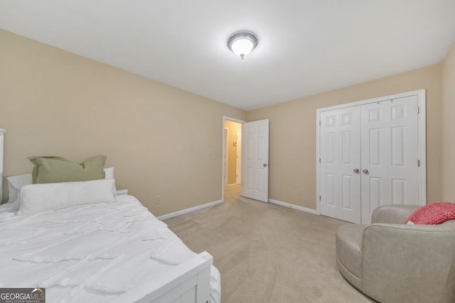 bedroom featuring baseboards, light carpet, and a closet