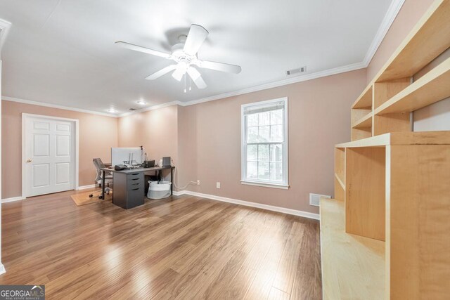 unfurnished office with wood finished floors, ceiling fan, ornamental molding, and baseboards