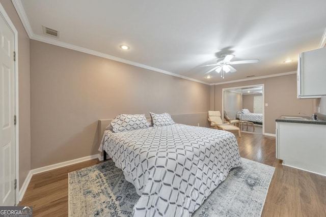 bedroom featuring wood finished floors, baseboards, crown molding, recessed lighting, and ceiling fan