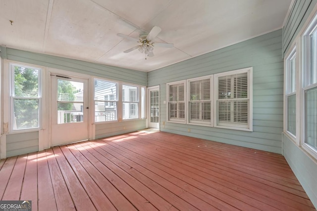 unfurnished sunroom featuring a ceiling fan
