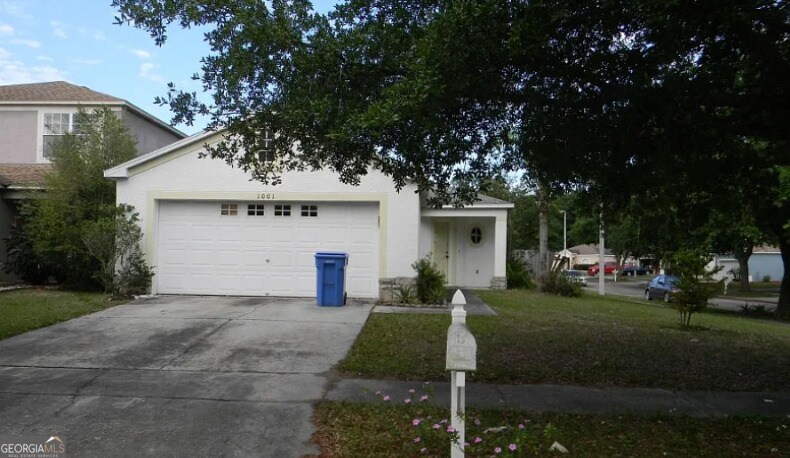 view of front facade featuring concrete driveway, stucco siding, and an attached garage