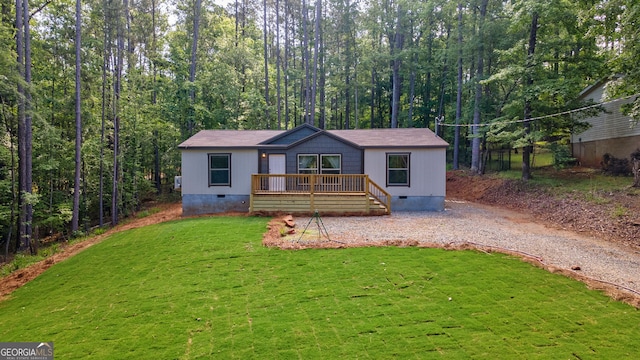 manufactured / mobile home with driveway, a front yard, a wooden deck, and crawl space
