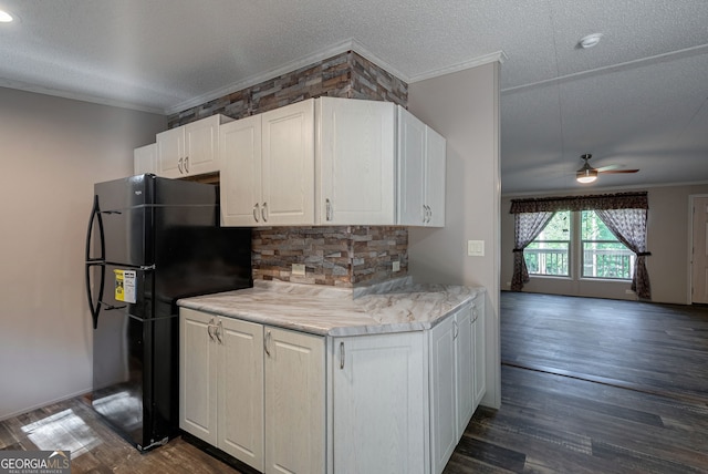 kitchen with freestanding refrigerator, a ceiling fan, ornamental molding, dark wood finished floors, and white cabinetry