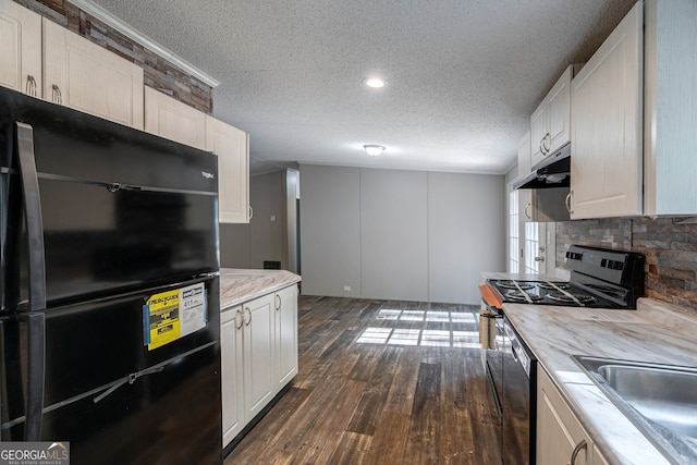 kitchen featuring freestanding refrigerator, under cabinet range hood, range with gas stovetop, dark wood finished floors, and a sink