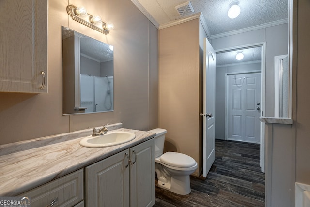 bathroom featuring toilet, wood finished floors, crown molding, visible vents, and vanity