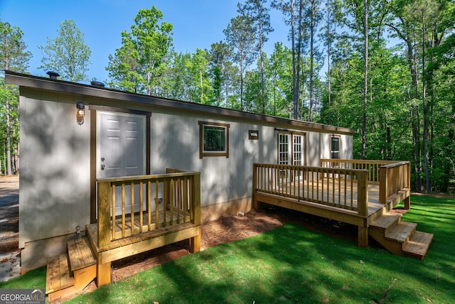 rear view of house featuring a deck and a lawn