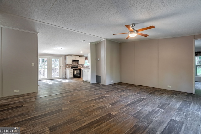 unfurnished living room with ornamental molding, a textured ceiling, dark wood-type flooring, visible vents, and ceiling fan