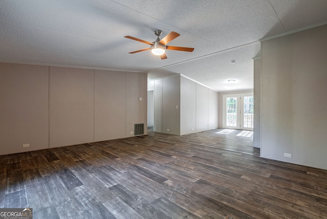 empty room featuring wood finished floors, a textured ceiling, ornamental molding, visible vents, and ceiling fan
