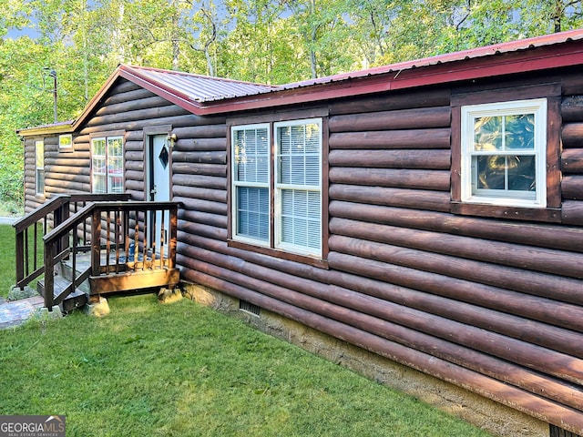 view of side of home featuring a yard, metal roof, log exterior, and crawl space