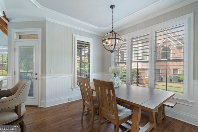 dining area featuring a chandelier, wood finished floors, ornamental molding, and wainscoting