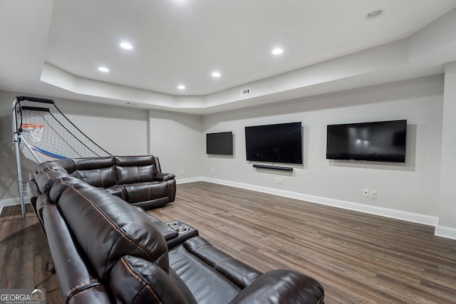 living area featuring baseboards, wood finished floors, recessed lighting, and a tray ceiling