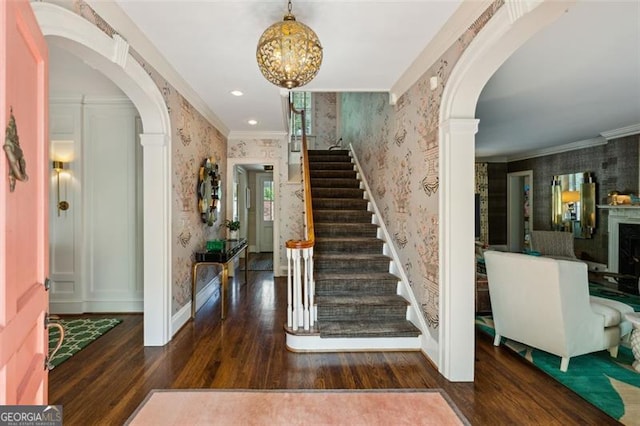 3086 Pine Valley Rd, Atlanta, GA 30305 - foyer entrance featuring wallpapered walls, arched walkways, wood finished floors, stairway, and crown molding