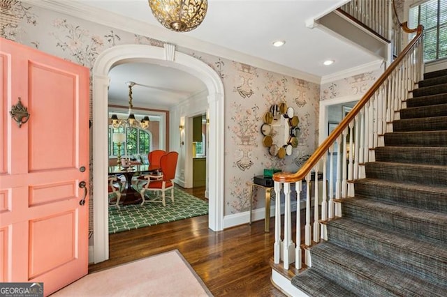 3086 Pine Valley Rd, Atlanta, GA 30305 - foyer entrance featuring ornamental molding, wallpapered walls, arched walkways, wood finished floors, and a chandelier