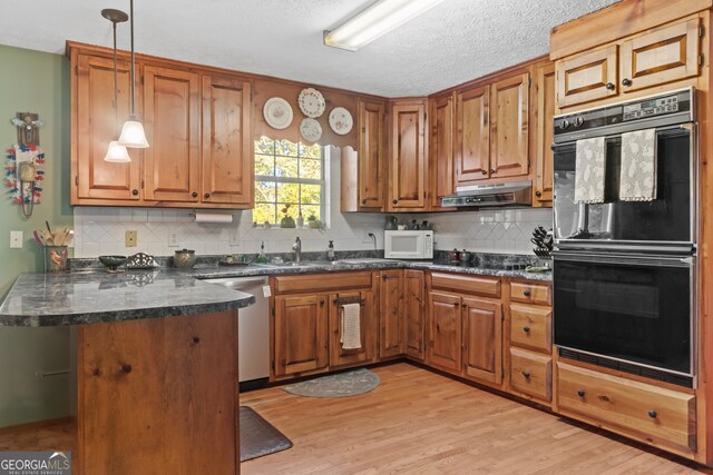 191 Roberts Way, Cornelia, GA 30531 - kitchen with a peninsula, brown cabinetry, white microwave, dishwasher, and dobule oven black