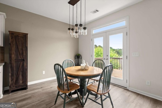 dining space featuring baseboards, french doors, light wood-style flooring, and visible vents