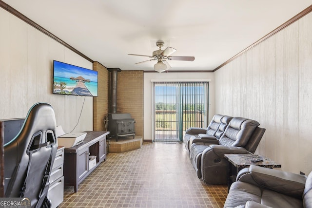 1240 C M Copelan Rd, Madison, GA 30650 - living room featuring ornamental molding, a wood stove, a ceiling fan, and wooden walls