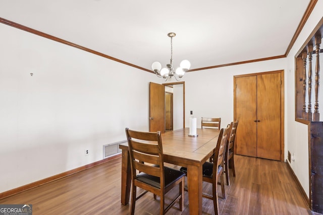 1240 C M Copelan Rd, Madison, GA 30650 - dining space with a chandelier, wood finished floors, crown molding, and baseboards