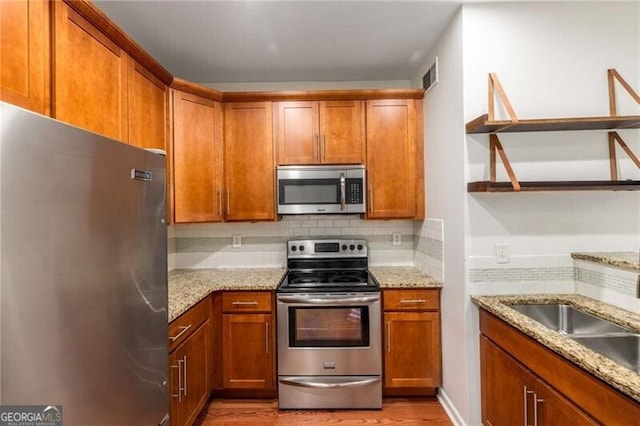 821 Ralph Mcgill Blvd NE Unit 2113, Atlanta, GA 30306 - kitchen with stainless steel appliances, open shelves, decorative backsplash, and brown cabinets