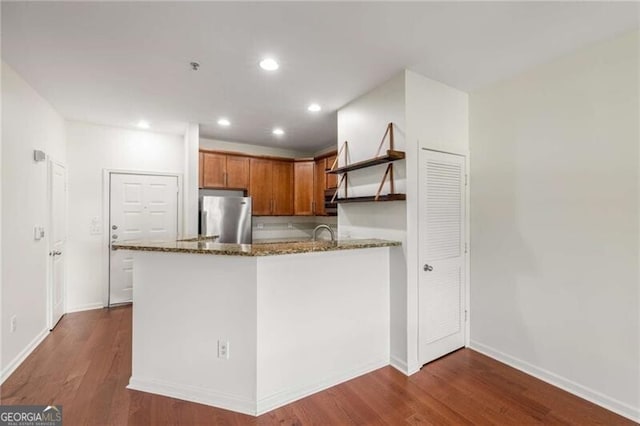 821 Ralph Mcgill Blvd NE Unit 2113, Atlanta, GA 30306 - kitchen with brown cabinetry, dark stone countertops, freestanding refrigerator, open shelves, and dark wood finished floors