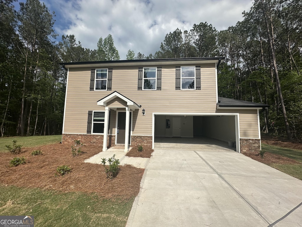 view of front of property featuring driveway, brick siding, and an attached garage