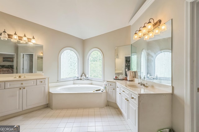 bathroom featuring a bath, tile patterned floors, two vanities, and a sink