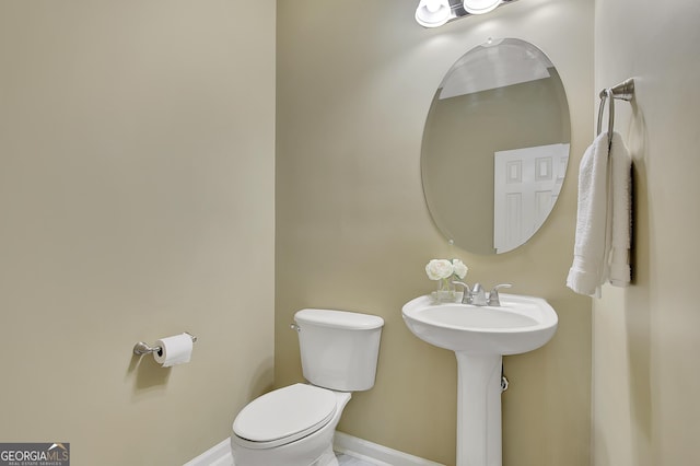 bathroom featuring toilet and baseboards