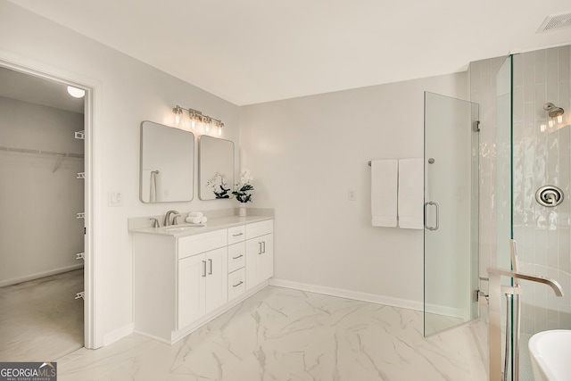 bathroom with marble finish floors, a stall shower, baseboards, and vanity