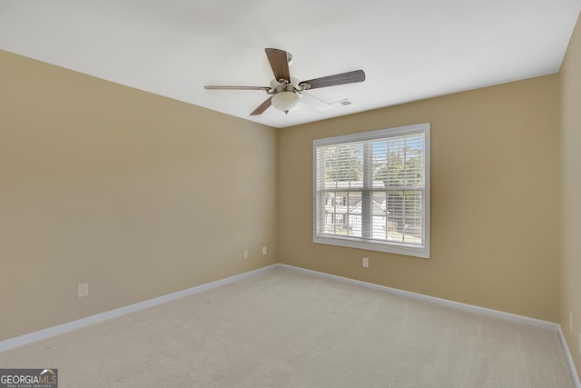 unfurnished room with a ceiling fan, light carpet, and baseboards
