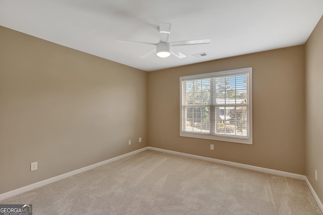 empty room featuring light carpet, baseboards, and a ceiling fan