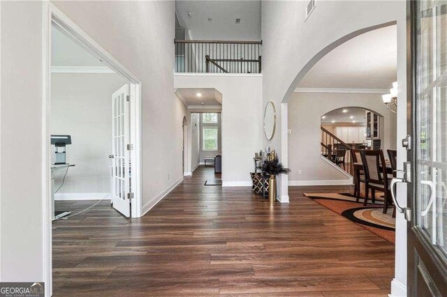 6375 Haystack Ct, Cumming, GA 30040 - foyer entrance featuring stairs, wood finished floors, visible vents, crown molding, and arched walkways