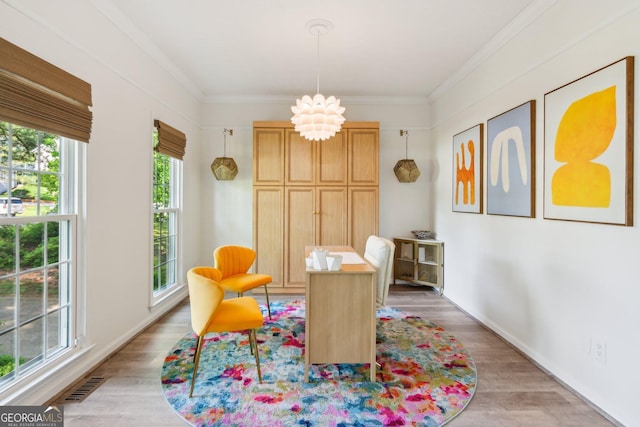 sitting room with crown molding, light wood-type flooring, visible vents, and an inviting chandelier