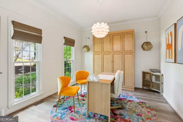 dining room featuring crown molding, light wood-style flooring, and visible vents
