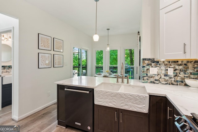 kitchen with stove, a sink, dishwashing machine, tasteful backsplash, and light wood-type flooring