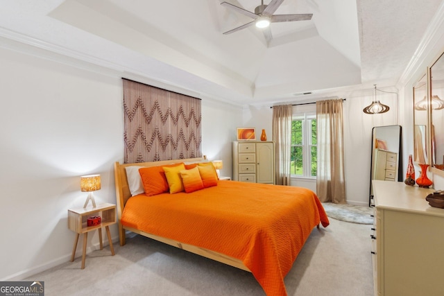 bedroom featuring baseboards, a tray ceiling, a ceiling fan, and light colored carpet