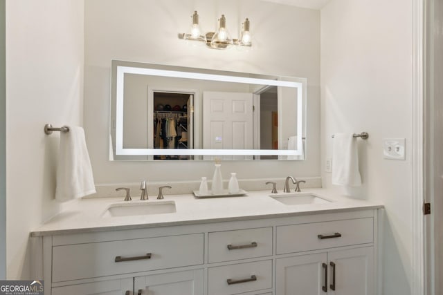 full bathroom featuring a chandelier, double vanity, a sink, and a walk in closet