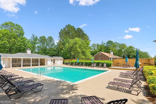 community pool featuring a patio and fence