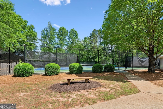 view of property's community with fence and a tennis court