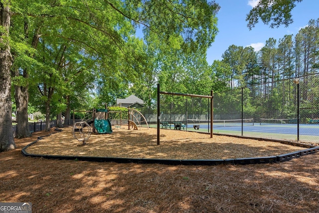 community play area featuring fence and a tennis court