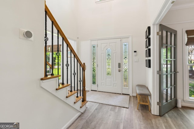 foyer entrance featuring stairway, a wealth of natural light, baseboards, and wood finished floors