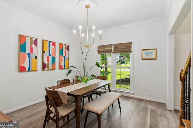 dining space with baseboards, an inviting chandelier, crown molding, and wood finished floors
