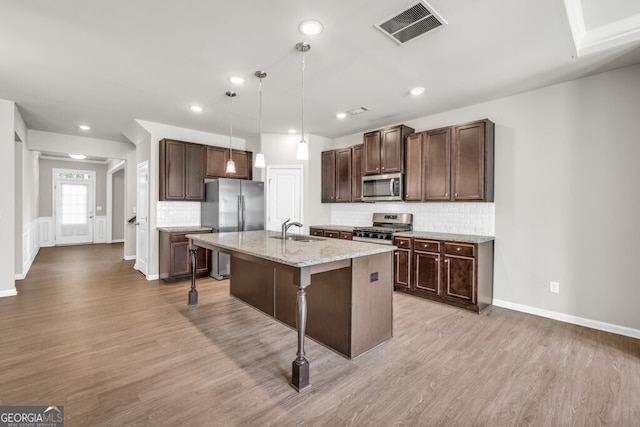 kitchen with stainless steel appliances, a sink, light wood-style floors, tasteful backsplash, and recessed lighting